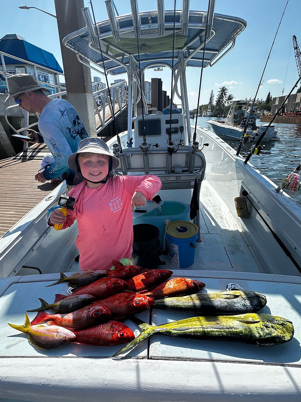 young boy pointing at fishing while standing inside a boat