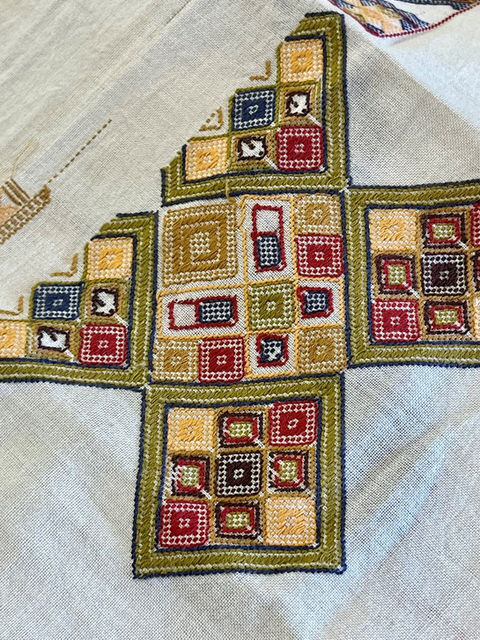 fabric detail with a multicolored geometric pattern in the shape of a cross and squares
