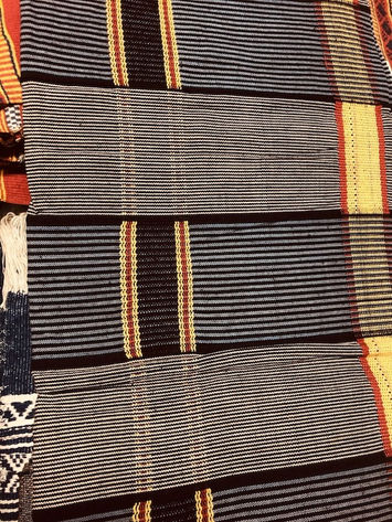 detail of African fabric with regular geometric decorations in blue, black, cream and red colors
