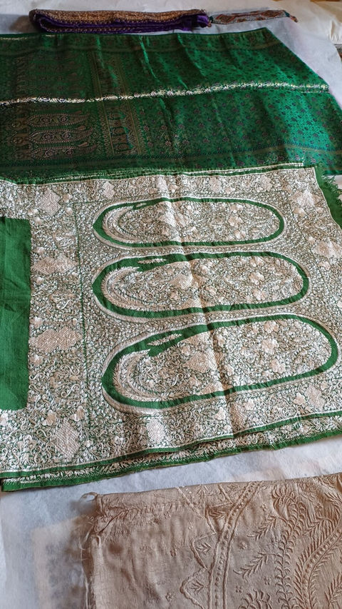 detail of a piece of silk fabric with green and silver linear floral geometric decorations