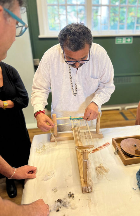 detail of hands in the act of weaving a piece of cloth on a loom