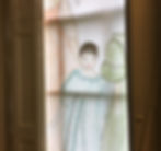 detail of a drawing stuck from a window with a doll in a night dress and some other dolls