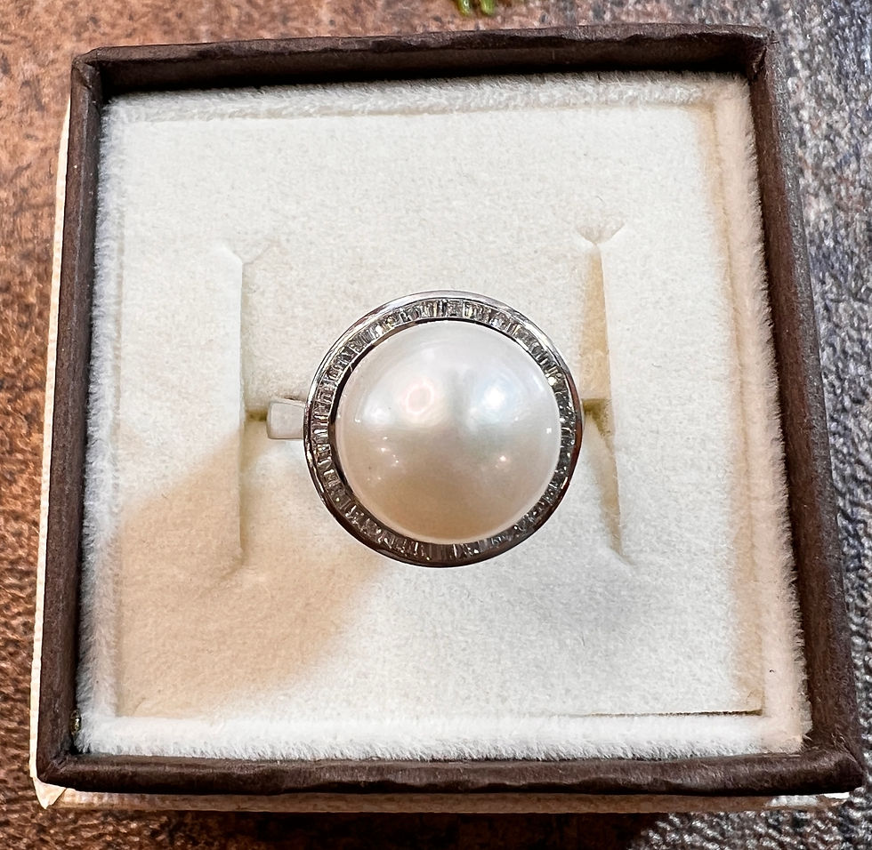 Złoty pierścionek z perłą słonowodną i diamentami w białym złocie próby 750, centralna perła około 12 mm otoczona diamentami