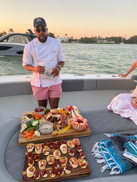 Chef serving appetizers and charcuterie board on a boat