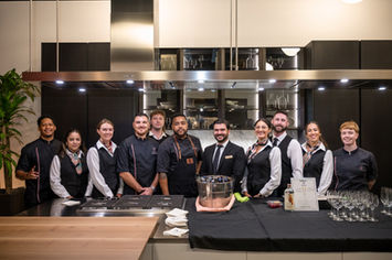 Diverse kitchen and service staff posing in a modern kitchen