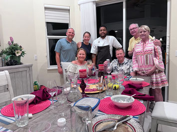 Chef and group of friends smiling at a dinner party table