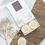 Thumbnail: 6 round shaped botanical wax melts with cream dried botanicals on top in a luxury match style box.