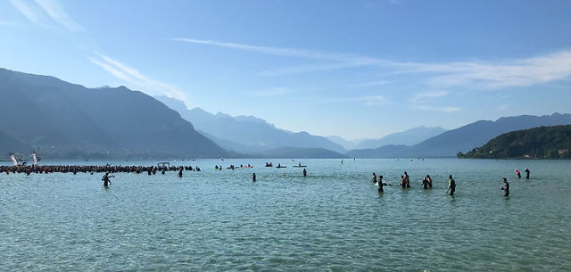 Triathletes wade out in lake Annecy, ready for the start of the race.