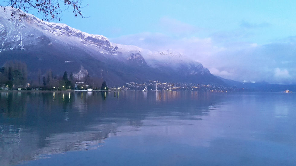 The eastern shore of lake Annecy in winter; Imperial Palace gardens are in the foreground left. Just to the right of this are the lights of Veyrier followed by Menthon St Bernard. Far right are the lights of the Palace Hotel.