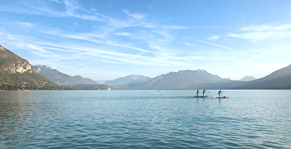 Three paddle boarders on lake Annecy.