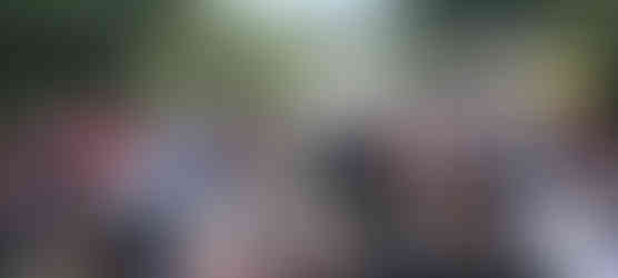 A couple dancing the tango surrounded by people watching, outside.