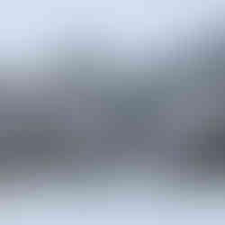 View of chateau at Menthon Saint Bernard looking up from fields below. Everything is covered in snow.