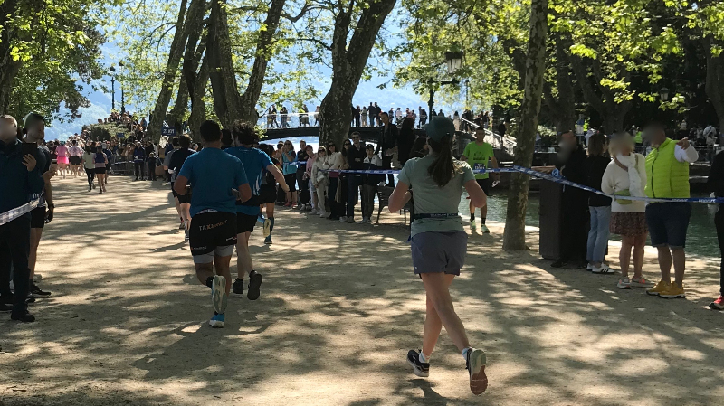 Runners head towards the finish in the Annecy marathon.. Le Pont d'Amour is in the background.