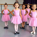 5 year old children in a dance class wearing pink leotards, pink skirts, and black tap sho