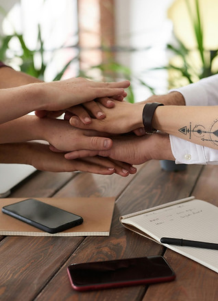 photo of hands of people in a pile  illustrating teamwork