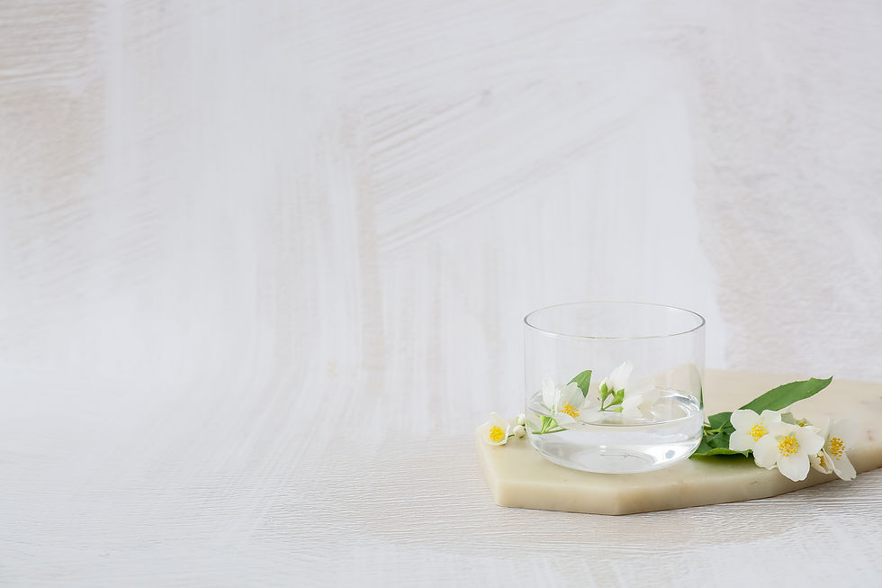 Composition with beautiful jasmine flowers and glass of water on light background.jpg