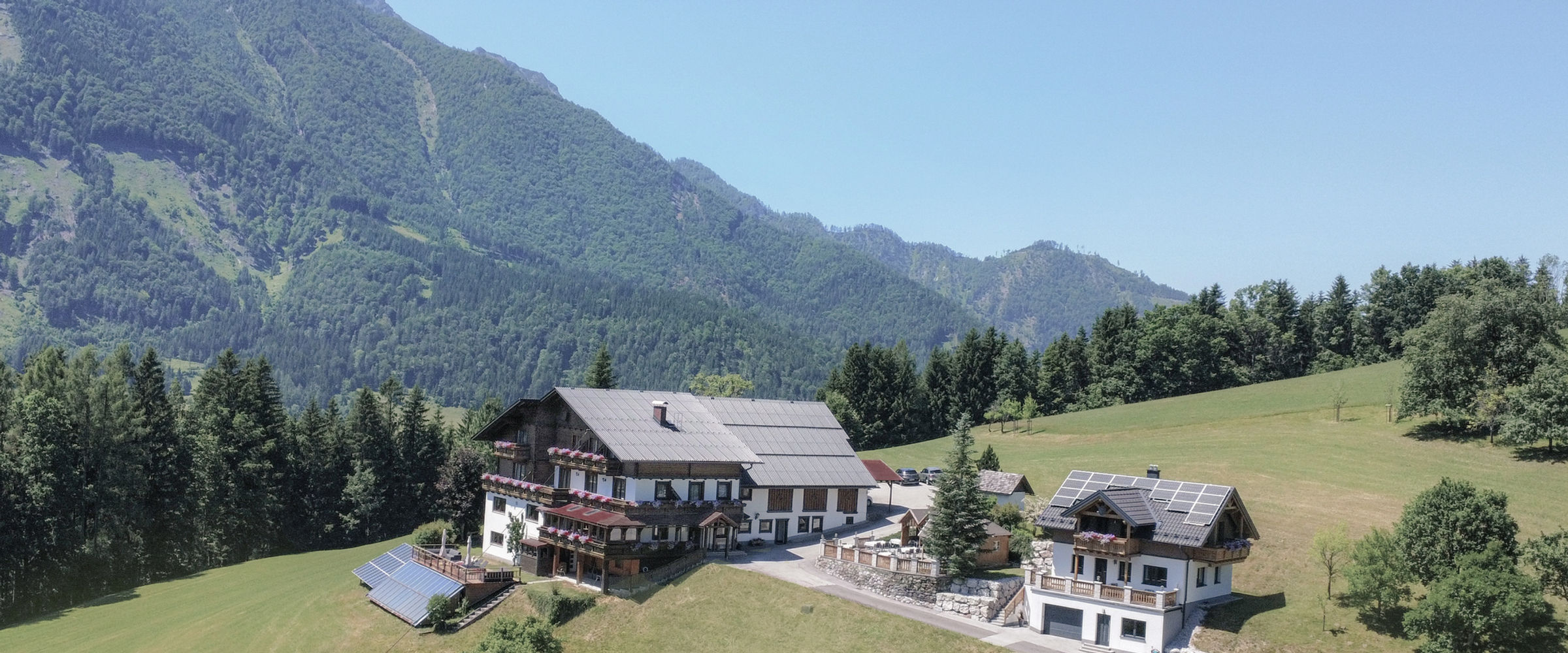 Hotel & Destillerie Sonnfeld vor dem Bergpanorama in Hinterstoder