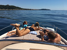sunbathing on the sun deck of speed boat with pendenis castle across falmouth bay in the distance