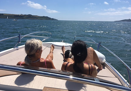 Dilly and her daughter relaxing on the sun deck as they head accross the Carrick Roads aboard their own private speed boat on a charter trip