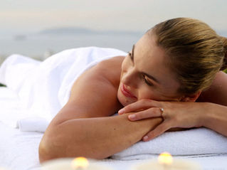 Woman receiving massage at Airbnb, white towels, smiling at partner