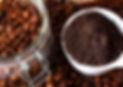 Jar of coffee beans and cup of ground coffee