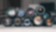 Photo of stacked vintage lenses reflecting the window and photographer.