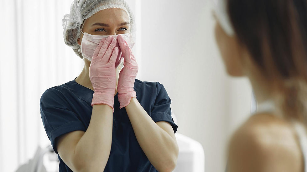 A smiling medical practitioner wearing gloves and a mask engages with a patient indoors.