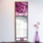 Slim Mackintosh stained glass mirror with a streaky lilac rose displayed on a white wall