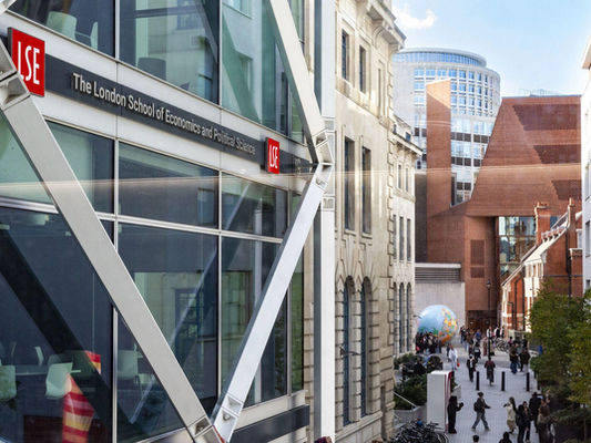 Modern LSE building with "The London School of Economics" sign, busy street.