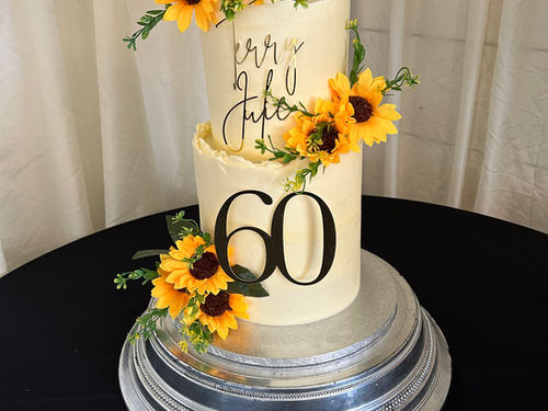 Two-tiered 60th birthday cake decorated with sunflowers