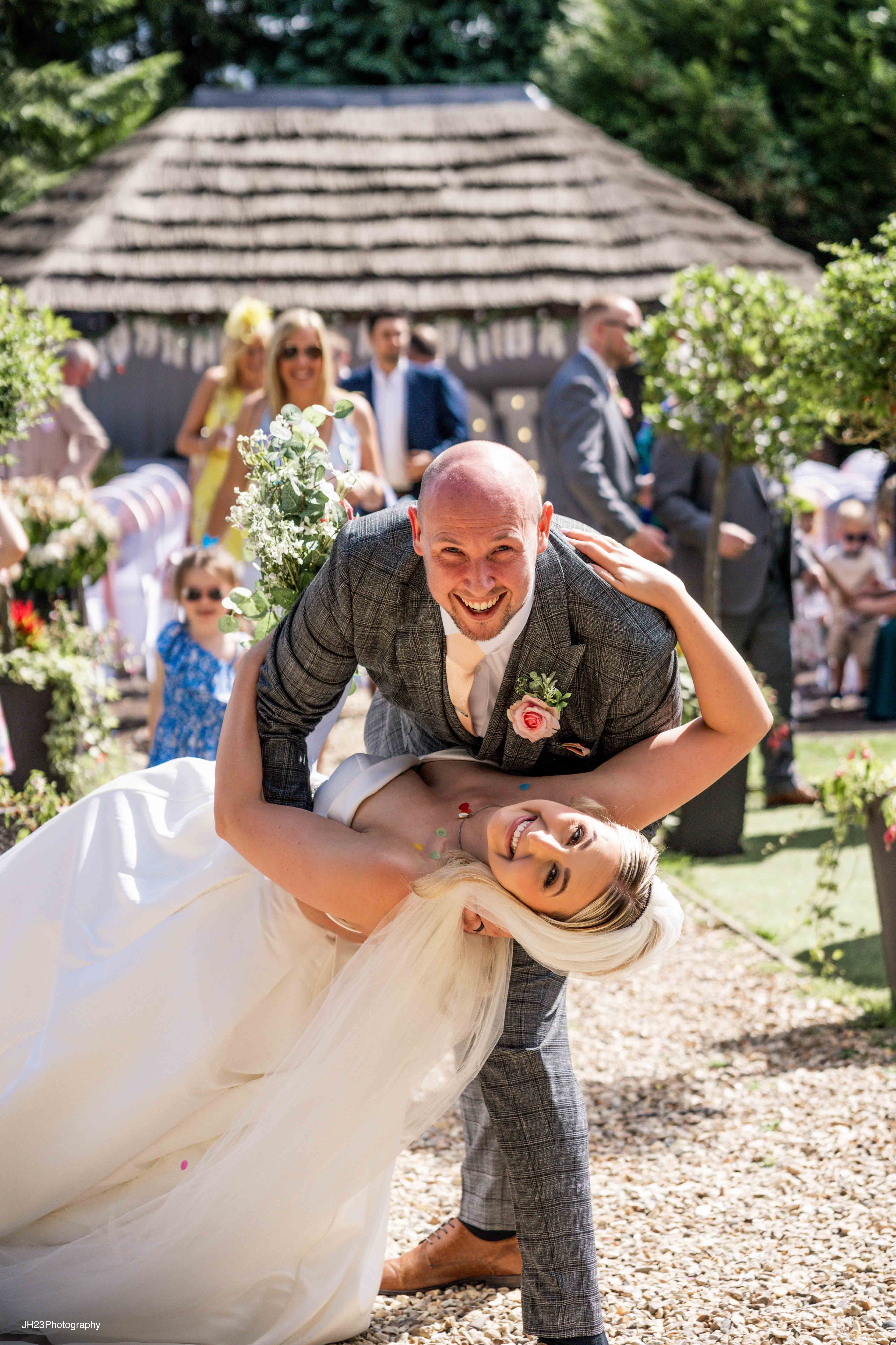 Happy couple playfully dips; joyful wedding celebration