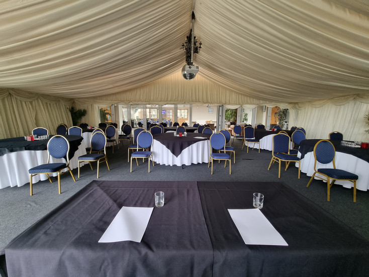 Spacious marquee event space prepared for a meeting