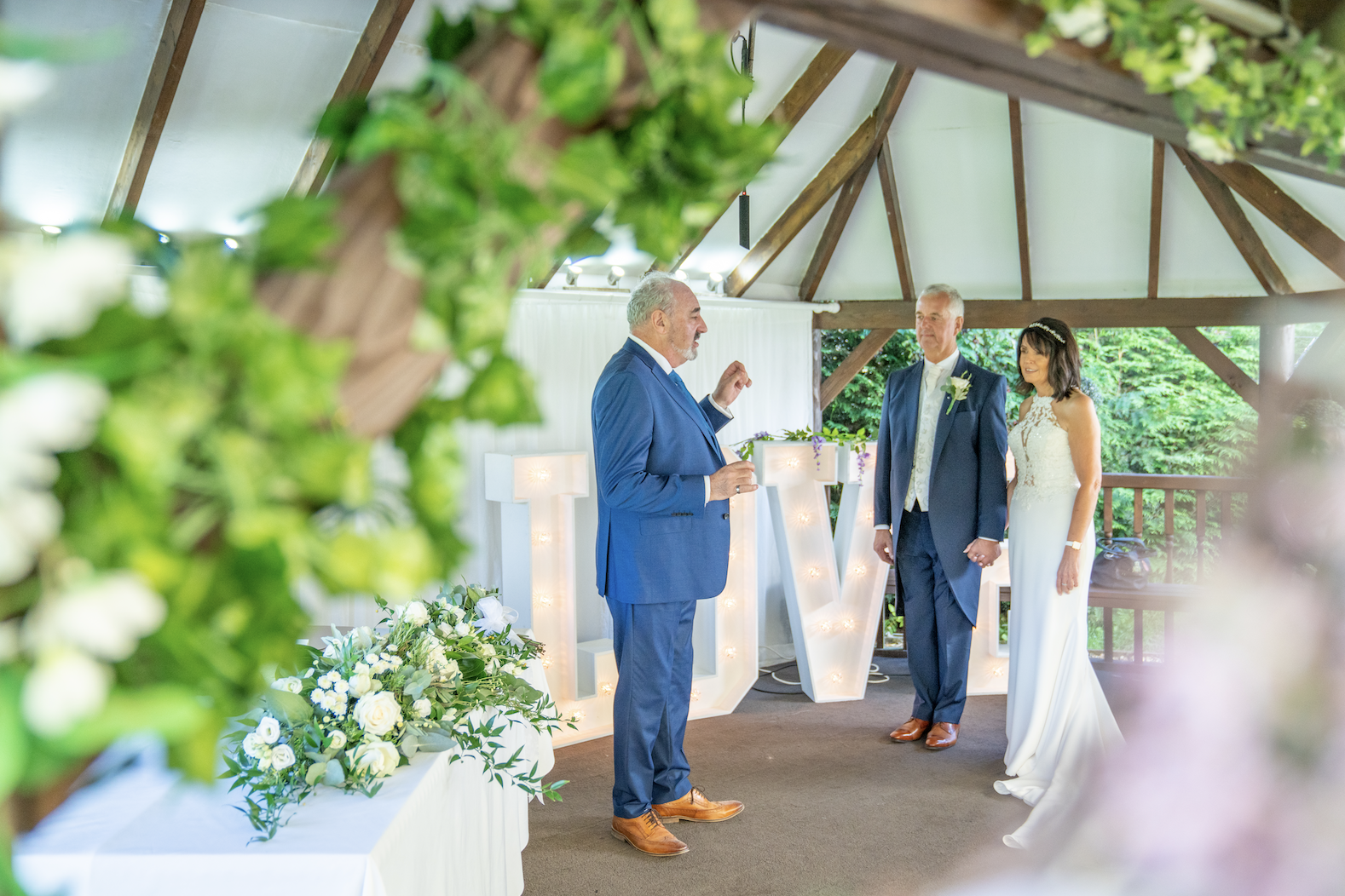 Wedding ceremony: officiant leads couple, LOVE letters