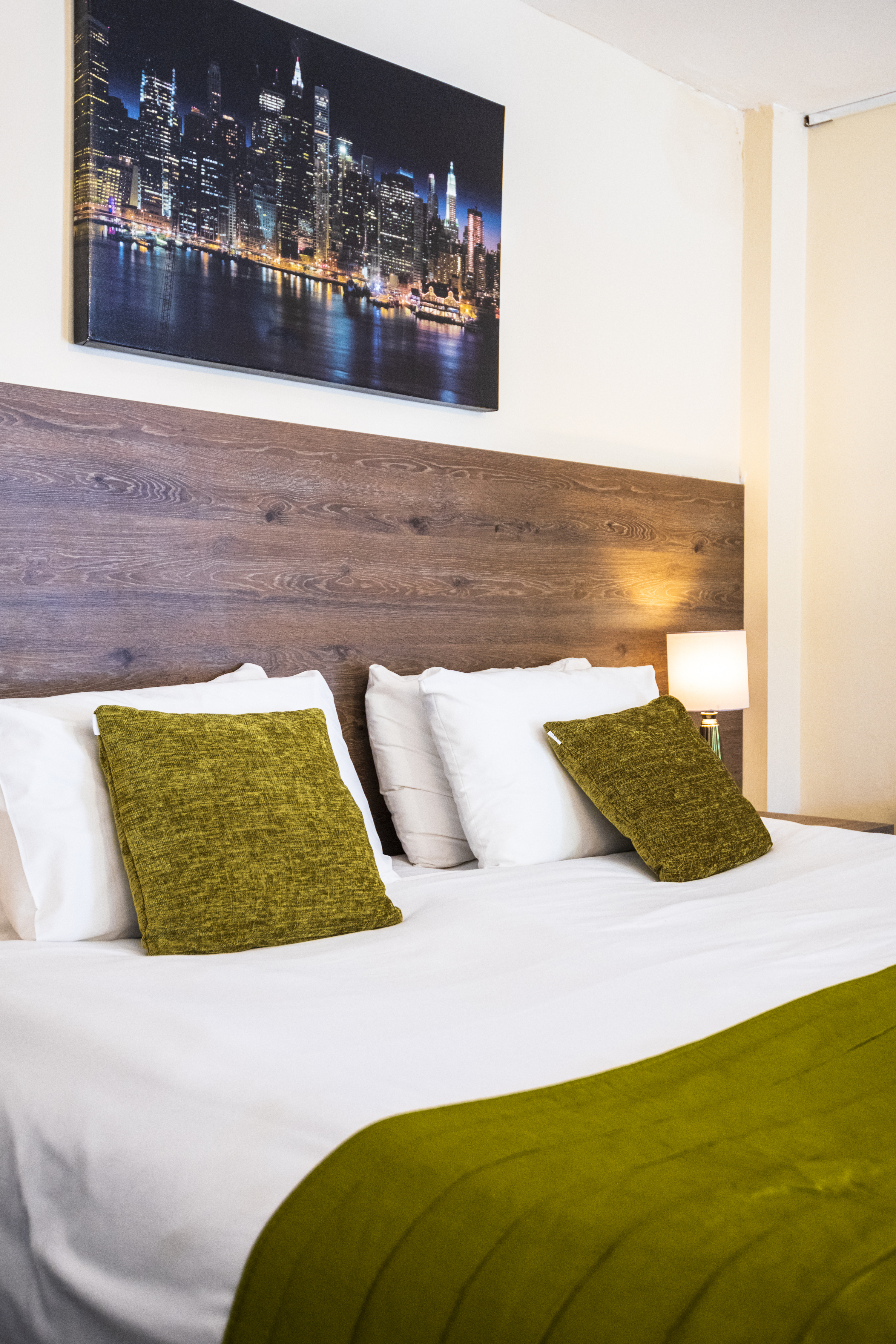 Comfortable double bed with olive cushions
