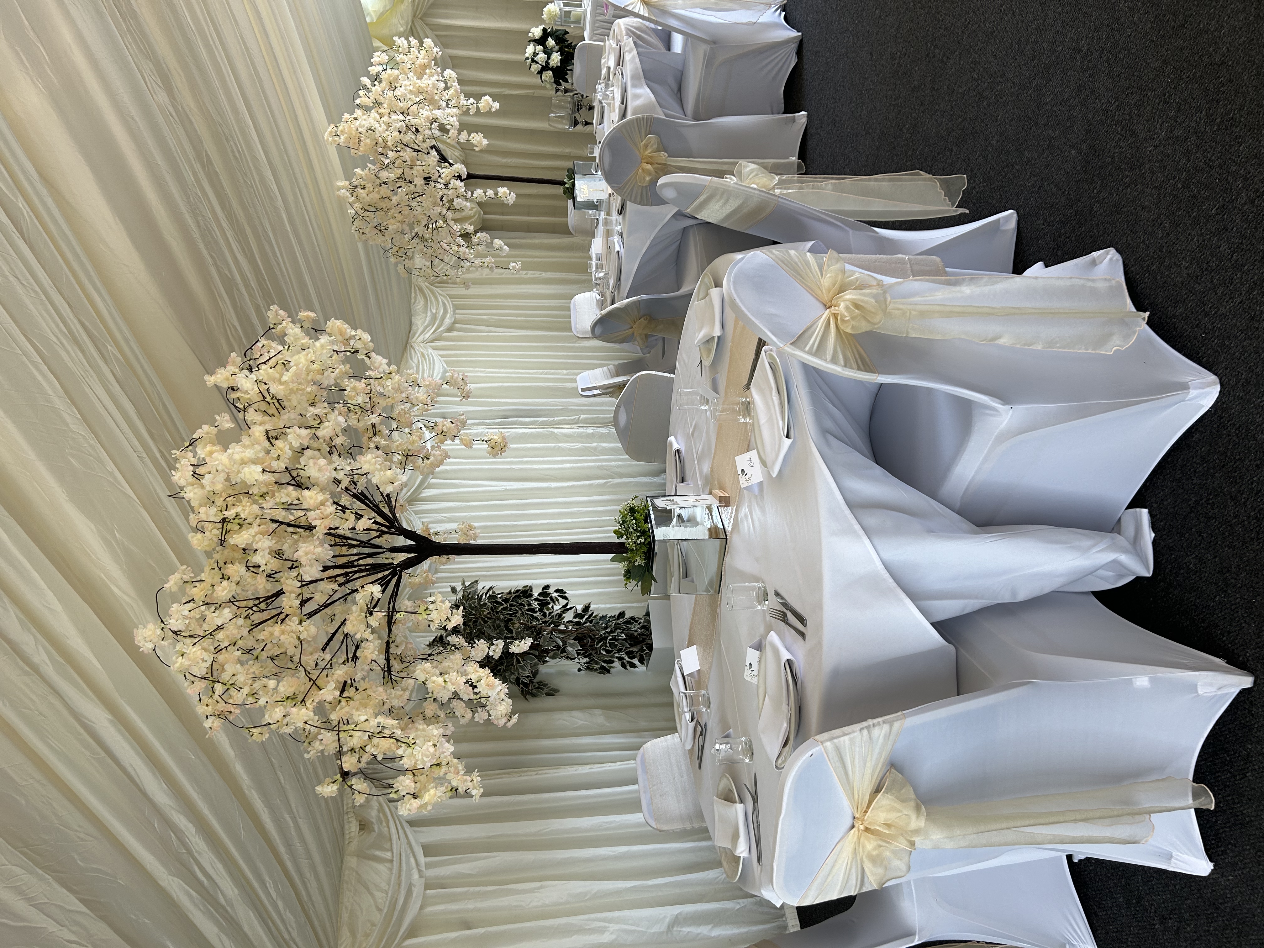 Elegant wedding reception tables with blossom tree centerpieces