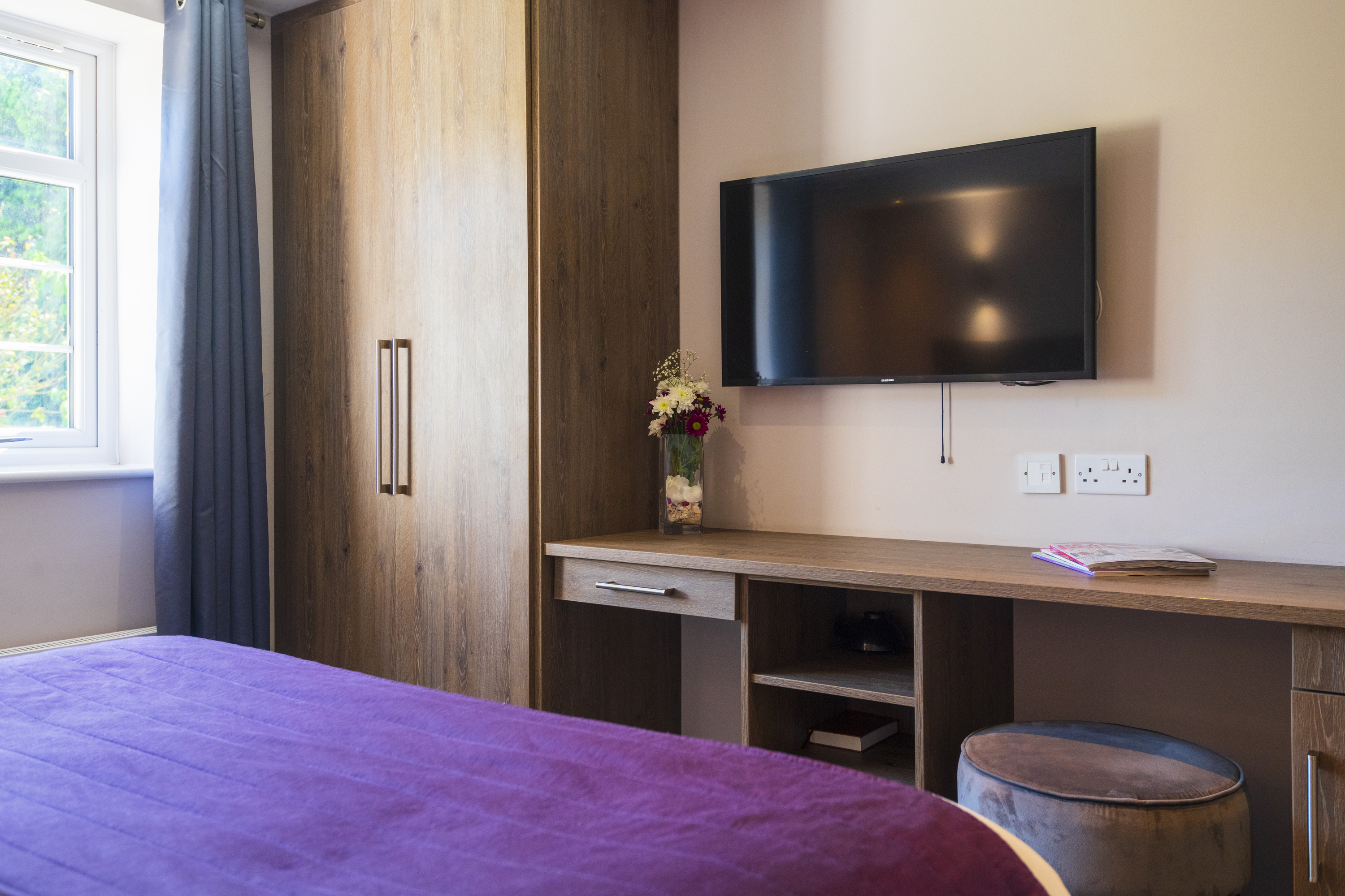 Modern hotel room with TV and wardrobe