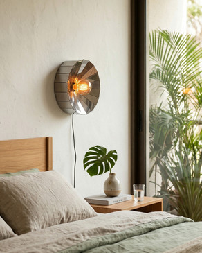 Luminária de parede compacta em aço inox com design geométrico criando efeito luminoso semelhante a dente-de-leão em parede clara