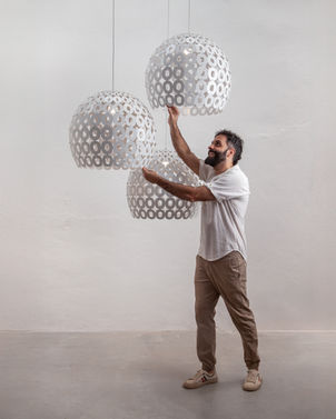 Três pendentes vazados de chapa metálica no atelier do designer Marcos Bravo