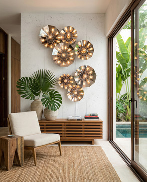 Composição de luminárias de parede em aço inox com design geométrico formando instalação luminosa em ambiente contemporâneo com jardim interno e mobiliário minimalista