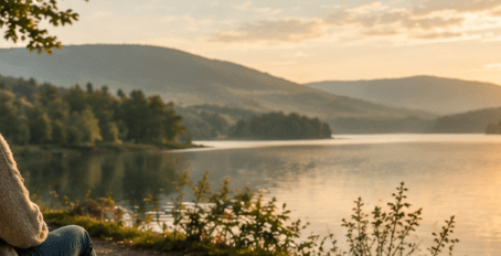 Personne assise face à un lac, en train de réfléchir, illustrant les schémas amoureux et les blessures émotionnelles.