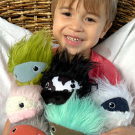 A young child smiles holding several Mimbleballs.