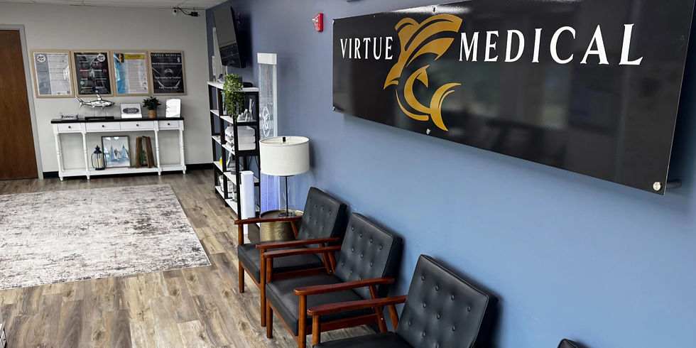 The lobby and reception area of Virtue Medical clinic in Blue Springs, MO, showcasing a large black and gold brand sign mounted on a blue wall next to modern black seating.