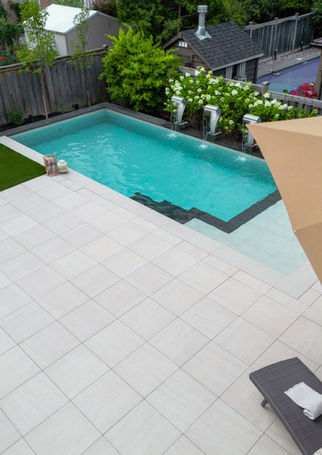 Aurora Central backyard seating area with outdoor furniture on porcelain tile patio beside the pool
