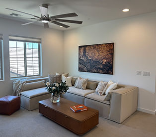 Modern family room in desert Ridge fully staged with obversized sectional, large wall art and fluted oak coffee table from CB2.
