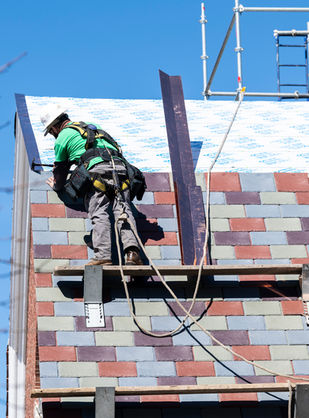 Image of a man installing new slate on a roof.