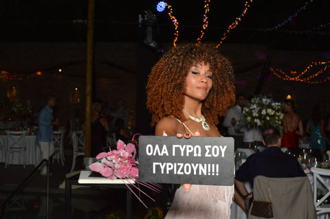 Woman holding sign with Greek text at a party. Cine Vermut Corporate Event Patra.