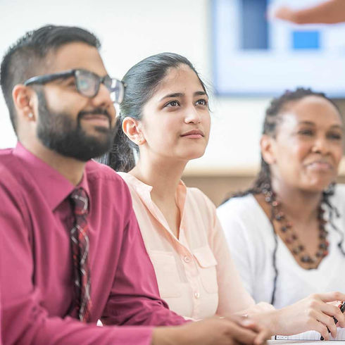 Man in glasses and pink shirt next woman in salmon shirt and woman with necklace in white shirt at a brainspotting training