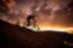 MTB riding down a mountain in the sunset