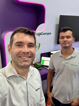 Dois funcionários da upCampo felizes no stand da upCampo. Ambiente de satisfação.