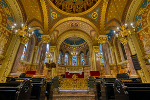 Historic hospital chapel in London, England, with ornate arches, gold detailing, stained glass windows, and a beautifully decorated altar.